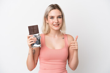 Young caucasian woman isolated on white background taking a chocolate tablet and with thumb up
