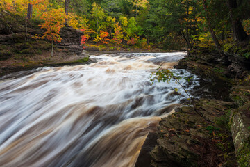 USA, Michigan. Fall colors at Presque Isle River waterfall on the south shore of Lake Superior.