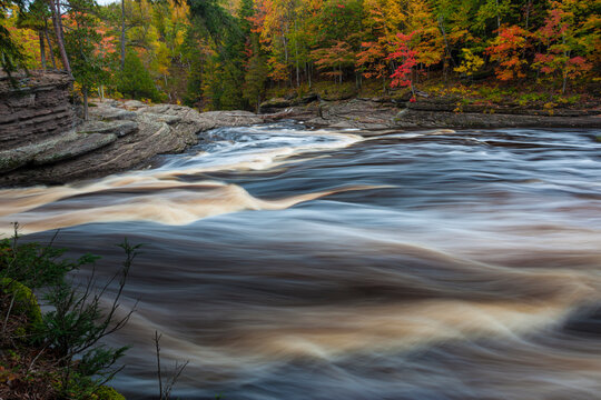 USA, Michigan. Fall colors at Presque Isle River waterfall on the south shore of Lake Superior.
