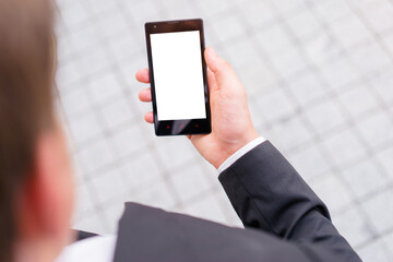 Copy space on the screen. Close up of the hand of the businessman with a smartphone outdoor.