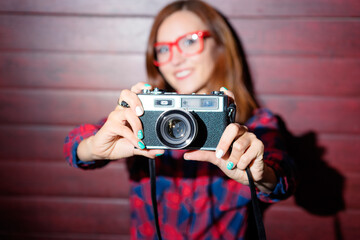 Close up shot of a vintage film camera hold by pretty young woman.