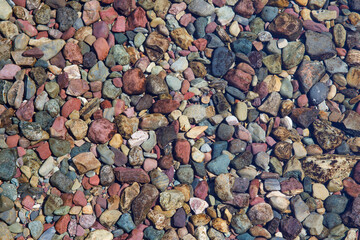 Red pebbles in lake pattern Glacier National Park, Montana