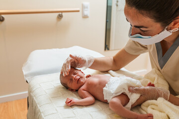 Female physiotherapist working with a newborn baby in a medical center.