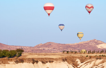 Travel and tourism by Turkey. Famous sightseeing Cappadocia, Anatolia. Beautiful landscape with mountains, caves and baloons in the sky.