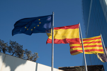 Flags of the EU European Union, Spain and Catalonia waving in sky
