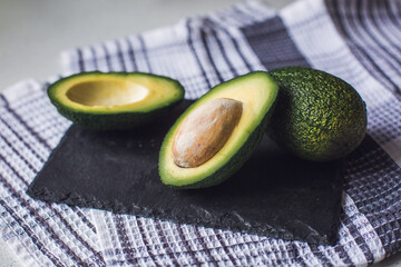 Green avocado close-up. Healthy food concept. Avocado halves with bone