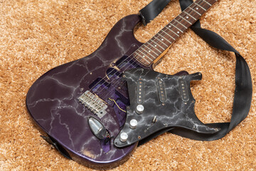 Broken electric guitar on the floor.