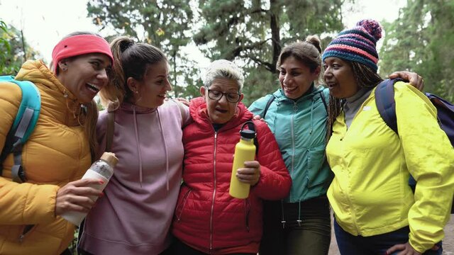 Group of women with different ages and ethnicities having fun walking in the woods - Adventure and travel people concept 