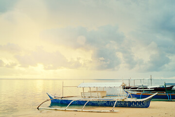 Fototapeta premium Beautiful colorful sunrise on the seashore with fishing boats. Philippines, Siargao Island.