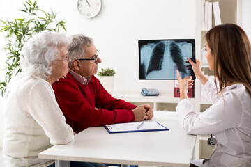 Doctor shows results to old patient x-ray of the lungs
