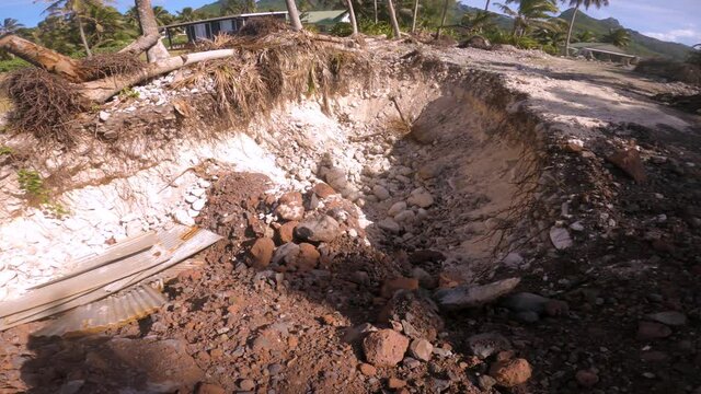 hand held still view of a mega dirt rocky coral hole in ground with digged up brown piles of stone rocky grunge texture at beach side sand patch