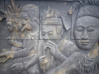 reliefs about the life of the indigenous people of Kalimantan on the walls of the city center park...