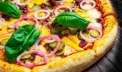 Pizza with Mozzarella cheese, Bolognese sauce, minced meat and vegetables. Italian pizza on wooden background.