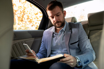 Businessman holding a phone and reading the notes