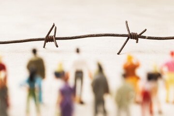 Barbed wire and plastic toy men, illegal migration concept