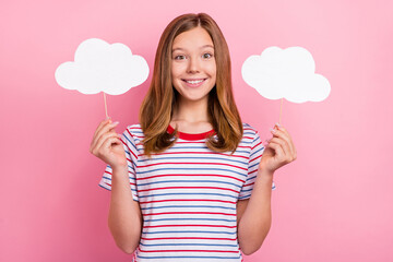 Photo of pretty teenager brown hairdo girl hold clouds wear striped t-shirt isolated on pink color background