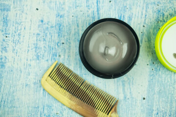 A box of hair wax with a comb for men