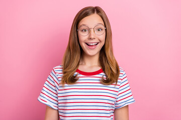 Photo of impressed little brown hairdo girl look camera wear eyewear striped t-shirt isolated on...