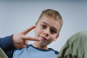 portret chłopaka wykonującego gesty dłonią 