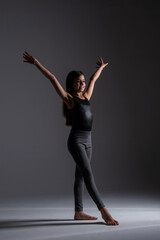 Obraz premium child doing artistic gymnastics movements, wearing gym clothes, photography taken in a studio