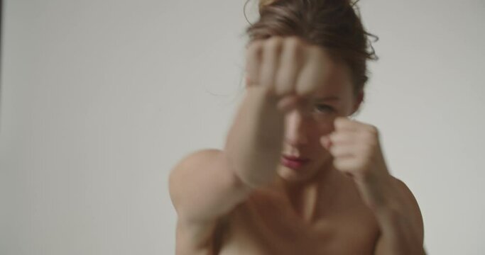 Young Woman With Fists Raised And Throwing Punches