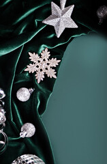 Christmas decoration with silver toys, stars, balls on turquoise velvet cloth. Top view. Copy space