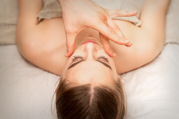 Fototapeta na wymiar Face massage with fingers of a masseur. Female facial skin care at a beauty spa salon
