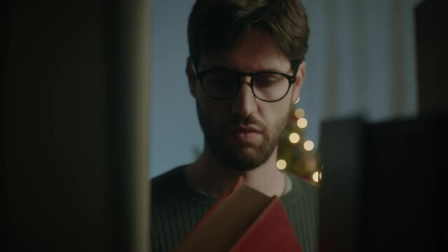 Giovane ragazzo prende libro dalla libreria in casa