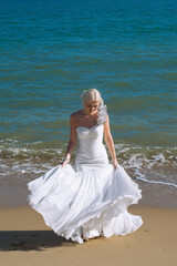 Fototapeta na wymiar the bride is dancing by the sea in a wedding dress