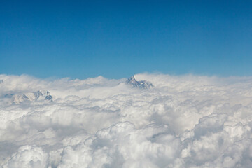 View at the Himalayas mountains and top of the Mount Everst above the clouds, seen from an airplane...