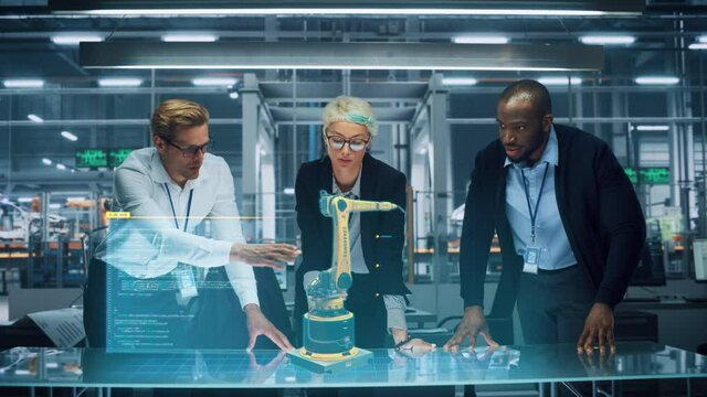 Industry 4.0 High-Tech Factory: Diverse Team of Robotics Engineers Working on Robot Arm Design, Using Augmented Reality Hologram to Manipulate 3D Model by Gestures. Engineering with Digital Technology