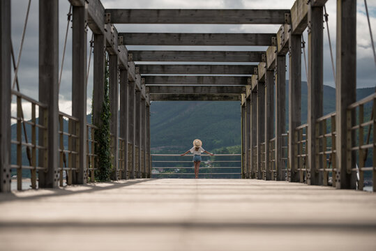 Female traveler on wooden pier near sea