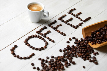 The word coffee written with coffee beans on a white wooden table
