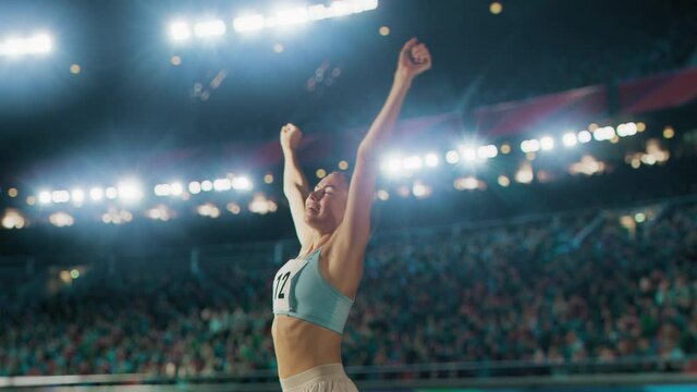 Portrait of Professional Female Athlete Happily Celebrating New Record on a Sport Championship with Stadium Crowd Cheering. Young Sportswoman Raising Arms Cheering. Winning, Victory, Success