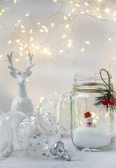 Fototapeta na wymiar Moscow, Russia, December 2021, Christmas card, background, decorative jar with a snowman inside, Christmas balls, a figurine of a deer and a garland of lights on a white background