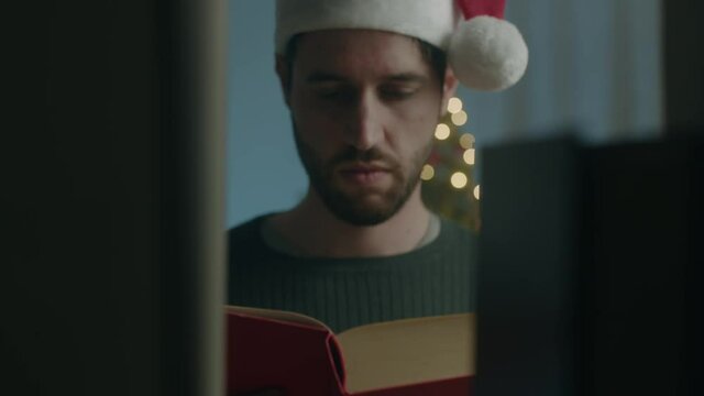 Ragazzo prende libro in libreria a Natale con cappello