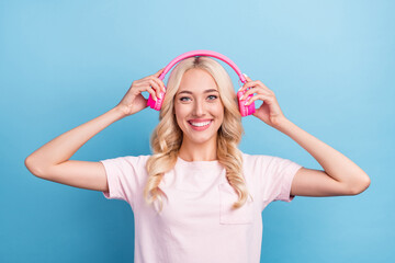 Photo of cute young blond lady listen music wear pink t-shirt isolated on blue color background