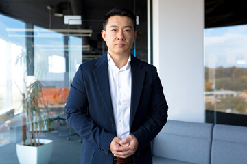 Portrait of successful business man boss Asian serious man looking at camera in modern office
