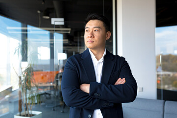 Fototapeta na wymiar Portrait of successful business man boss Asian serious man looking at camera in modern office