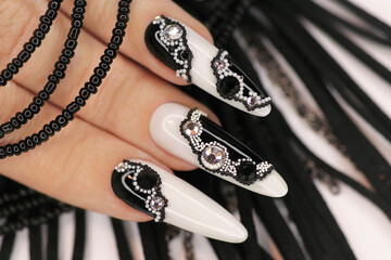 Black and white manicure with rhinestones on long gel nails.