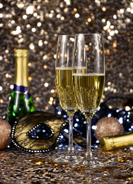 Two glasses of champagne at New Year's Eve party golden shiny background stock images. Two glasses champagne against holiday lights stock photo. New Year party still life images