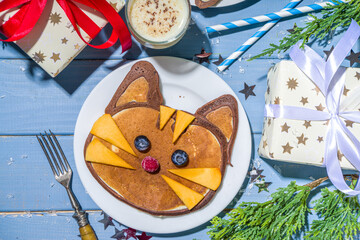 Christmas New Year morning breakfast, kids festive brunch snack. Funny  tiger pancakes, creative New Year 2022 symbols pancakes made with with berries, chocolate and vanilla dough