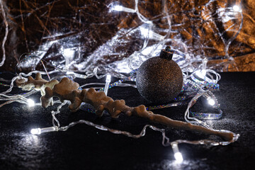 Christmas decorations: a ball and an icicle, tinsel, and a garland, on a silver and golden background. Christmas tree toys create a desire to celebrate Christmas and New Year.