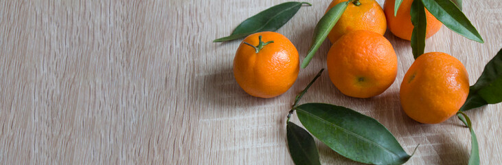 Tangerines or fresh tangerines on a wooden background. Tangerines with green leaves. Organic tangerines. copyspace