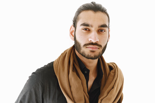 Young muslim man posing casually over white wall. Studio, isolated.