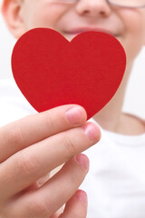 Obraz premium valentine's day. A white-haired boy gives a heart and smiles.
