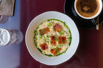 Bulgur porridge with bacon and greenery. Healthy food in restaurant. Modern breakfast not at home
