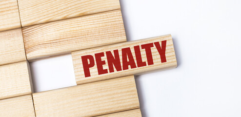 On a light background, wooden blocks with the text PENALTY. Close-up top view.