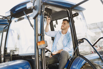 Male sitting comfortably on a big blue tractor