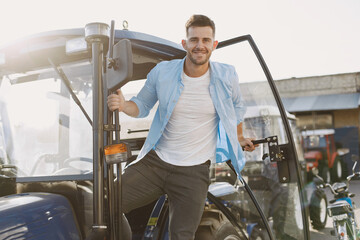 Male standing by the blue tractor